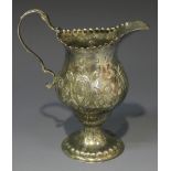 A George III silver cream jug with foliate capped scroll handle, the baluster body with festoon