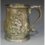 A George II silver tankard of baluster form, decorated in relief with a scroll cartouche and