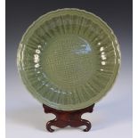 A Chinese Longquan celadon glazed circular dish, Ming dynasty, the centre carved with a trellis