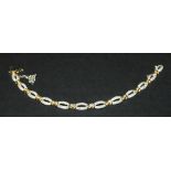An 18ct two-colour gold and diamond set bracelet, formed as a series of pierced oval links