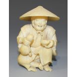 A Japanese ivory okimono carving, Meiji period, modelled as a seated farmer wearing a coolie hat and