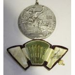 A Paris 1900 Exposition plated medallion, diameter approx 8cm, together with a leather fan shaped