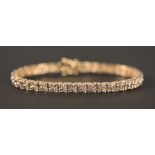 An 18ct gold and diamond set bracelet, formed as a row of flowerheads, each link claw set with