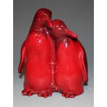 A Royal Doulton flambé glazed figure group of two penguins, model No. 103, modelled standing side by