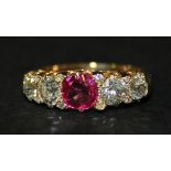 A gold, ruby and diamond set five stone ring, mounted with the cushion shaped ruby between two pairs