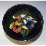 A Moorcroft pottery circular bowl, the interior decorated with orchid design on a dark blue