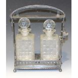 An early 20th Century Continental .900 silver two bottle tantalus with locking handle above a