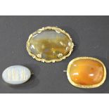 A gold mounted oval cornelian set brooch, the mount with engraved decoration, a Victorian oval agate
