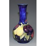 A Moorcroft pottery vase, circa 1920s, the narrow neck and bulbous body decorated with Wisteria