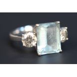 A white gold, aquamarine and diamond three stone ring, claw set with the rectangular step cut