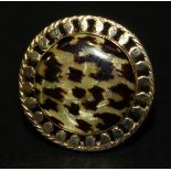 A 9ct gold dress ring of circular form, with a leopard skin effect finish within a beaded border,