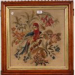 A late Victorian woolwork panel of a parrot and flowers, within a bird's eye maple frame, approx