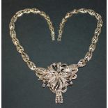A diamond set pendant necklace, the detachable front in a pierced openwork floral design, with a