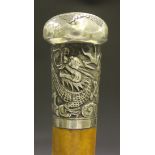 A 19th Century Malacca walking cane, the Chinese white metal handle decorated with a dragon,