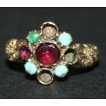 A gold, turquoise and garnet set cluster ring, mounted with four turquoise and two garnets, the