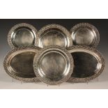 An Edwardian silver six-piece part dinner service, each piece with cast guilloche style rim filled