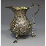 A George II silver cream jug, the low bellied body chased with a scroll cartouche between country