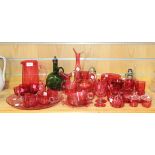 A collection of cranberry glass, 19th Century and later, including custard cups, a jug of tapering