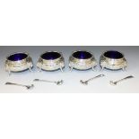 A set of four silver circular salts, each with gadrooned rim above a squat body decorated with