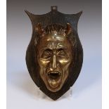 A late 19th Century gilt patinated cast bronze mask in the form of a horned man with open mouth