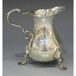 A George III silver cream jug with foliate capped scroll handle, raised on three scroll legs, London