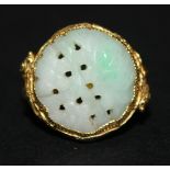 A Chinese gold and carved jade ring of circular form, pierced and engraved with floral decoration,