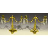 A pair of 19th Century French cast ormolu twin branch candelabra, each foliate sconce hung with