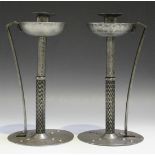 A pair of early 20th Century Coberg pewter candlesticks, each sconce above a drip pan on a