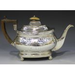 A George III silver teapot of cushion form engraved with a band of scallop shells and scrolls,