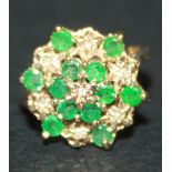 A 9ct gold, emerald and diamond set hexagonal cluster ring with pierced decoration, ring size approx