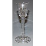 A wine glass, mid-18th Century, with rounded funnel bowl on a plain stem and fold-over foot,