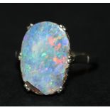 A white gold ring, claw set with an oval opal doublet, detailed '18ct', ring size approx Q1/2 (