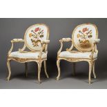 A pair of 18th Century Rococo period white painted and gilt showframe open armchairs, the oval backs