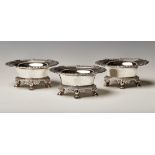 A set of three Regency silver oval salts, each flared body engraved with a crest beneath a cast