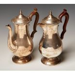 A pair of George V silver café-au-laits, each of baluster form with scroll handle, on a circular