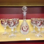 A Bohemian cut glass decanter and 6 glasses with red panels and bird decoration.