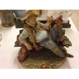 A Capodimonte figure of a tramp on a bench with a squirell signed B. Merli.