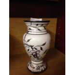 An antique white glass vase with silver overlay.