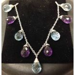 18ct white gold chain bracelet with 4 amethyst & 5 blue topaz faceted stones suspended.