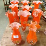 11 orange Murano glass vases with multicoloured flower design.