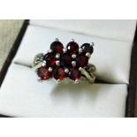 Ladies silver dress ring set with red stones and marcasite shoulders. Size P.