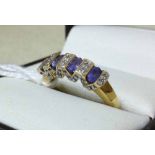 A ladies 14ct gold tanzanite and diamond ring in unusual zig-zag mount - size N.