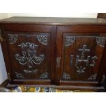 An antique oak 2 door church cupboard with carved doors, for ecclesiastical items. 80cm x 53cm x