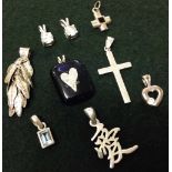 9 assorted silver pendants, some set with crystals.