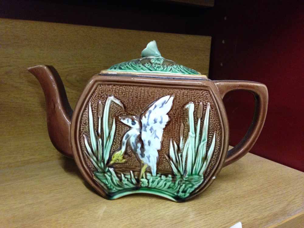 An antique majolica teapot with crane decoration