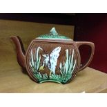 An antique majolica teapot with crane decoration