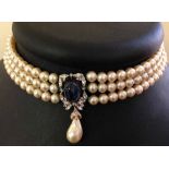 Faux pearl choker necklace with 3 strings of faux pearls and central blue domed cabouchon with