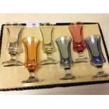 Box of pastel lustre glass sherry glasses.