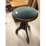 A green upholstered piano stool.