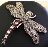 Large silver dragonfly brooch with marcasite set wings and body. Tail set with red and white stones.